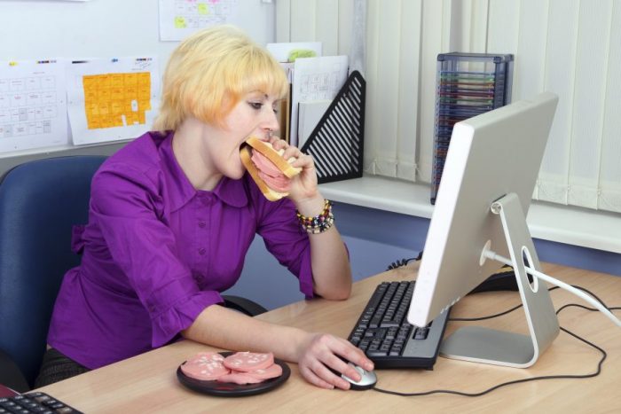 Женщина ест на рабочем месте